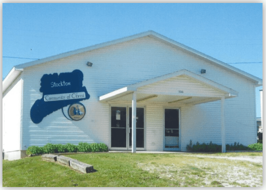 Stockton Community of Christ church exterior, featuring a white building with blue signage and a welcoming entrance under a canopy.